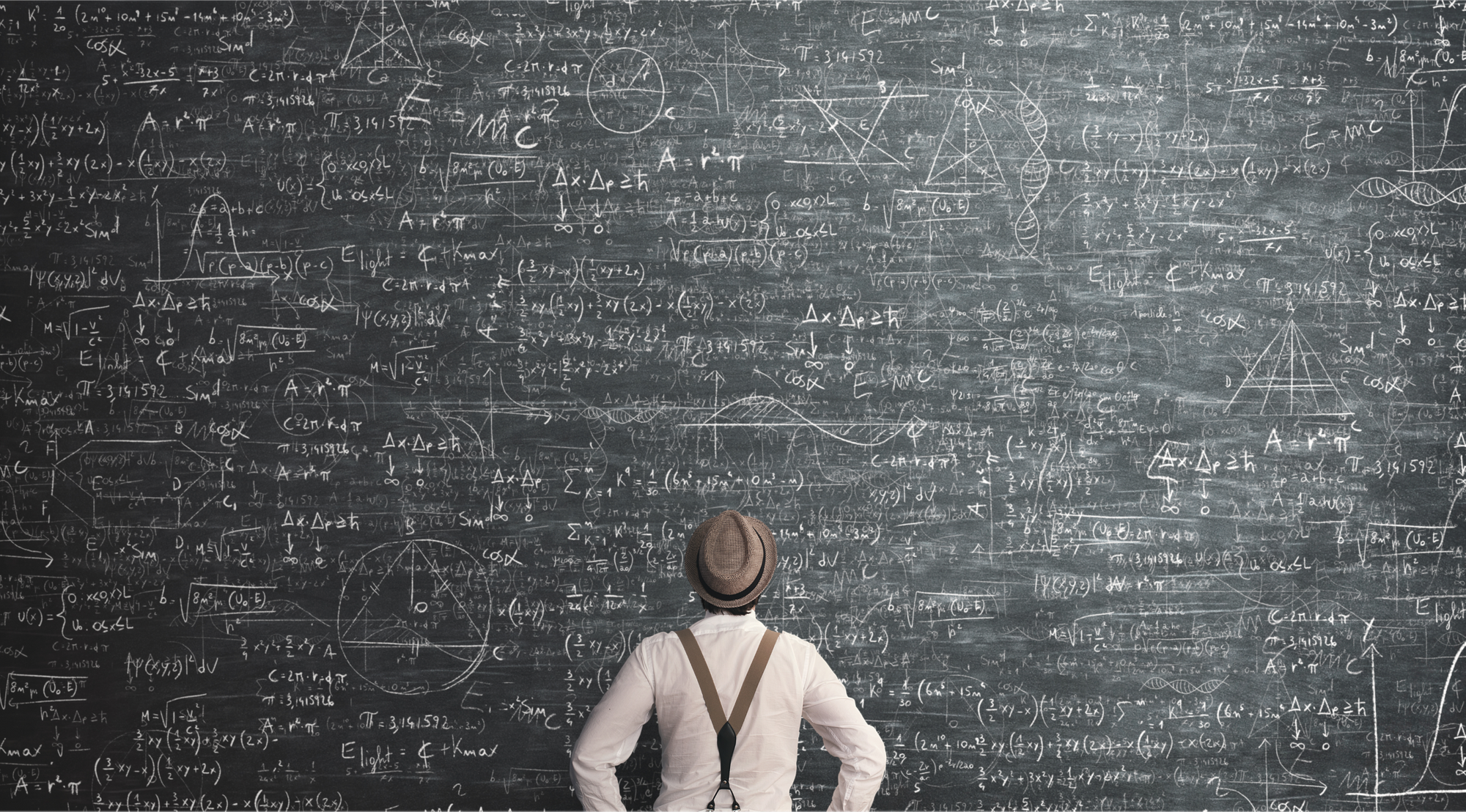 A person staring at a big black board with lots of equation