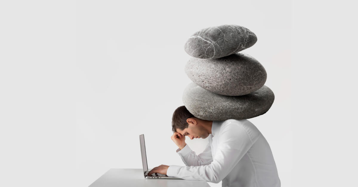 A stack of boulders on a man's shoulder who is working