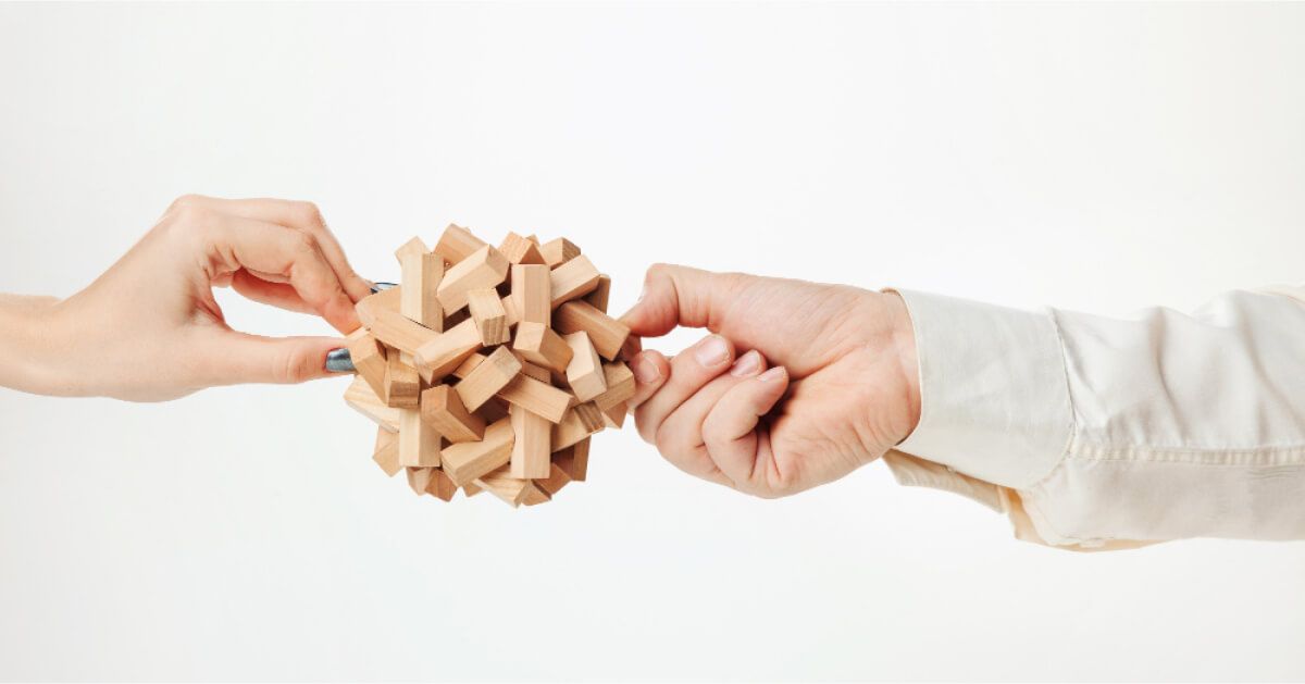 Two people trying to solve a puzzle cube