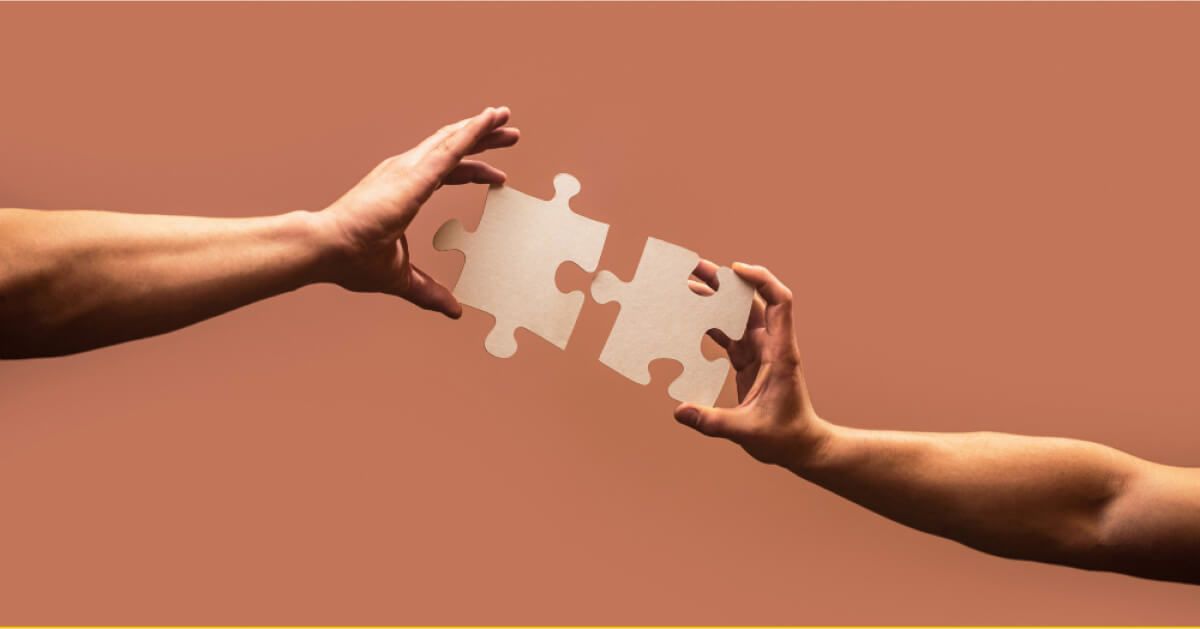 Two hands fixing a jigsaw puzzle