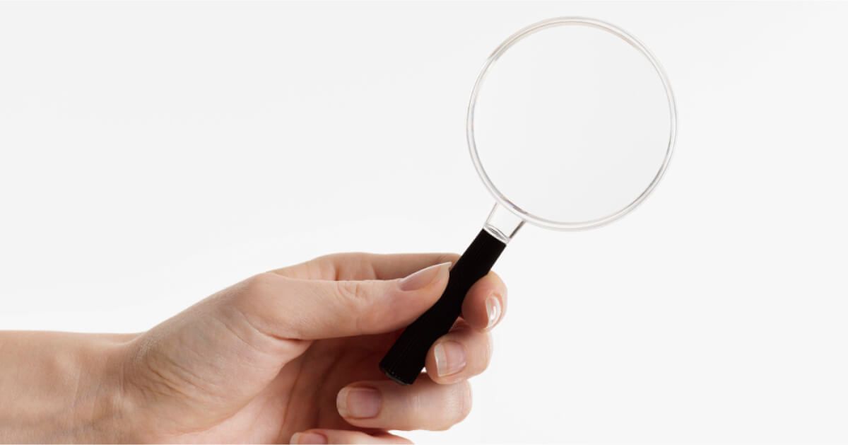 A person is holding a magnifying glass