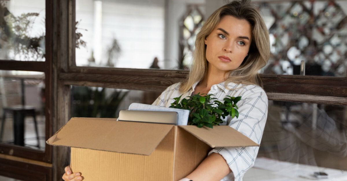 A woman carrying a box with her things