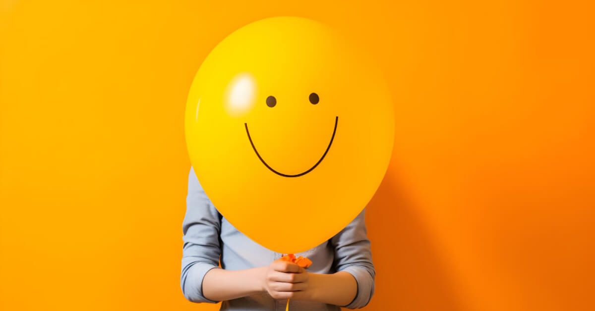 A man holding a smiley balloon