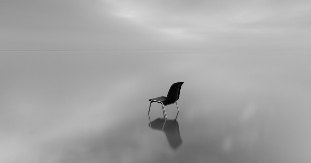 A black chair in the middle of the sea