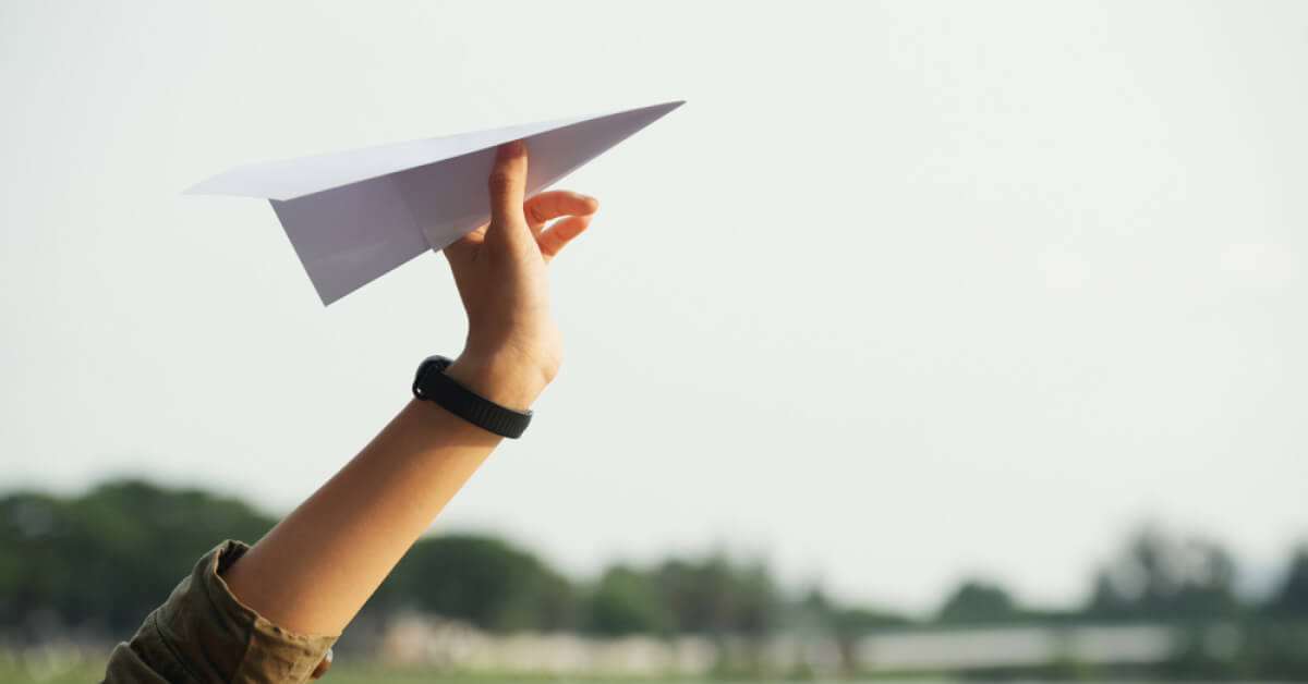 A person holding a paper rocket