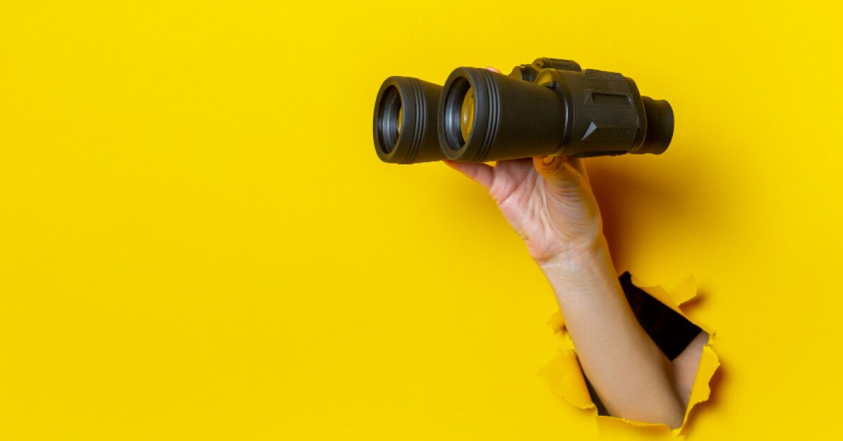 A hand holding a binocular