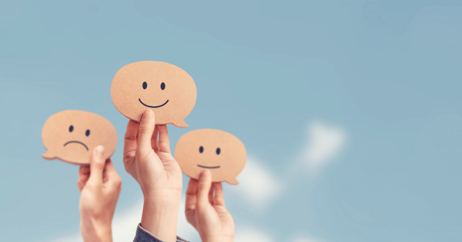 Employees are holding smiley emojis in their hands