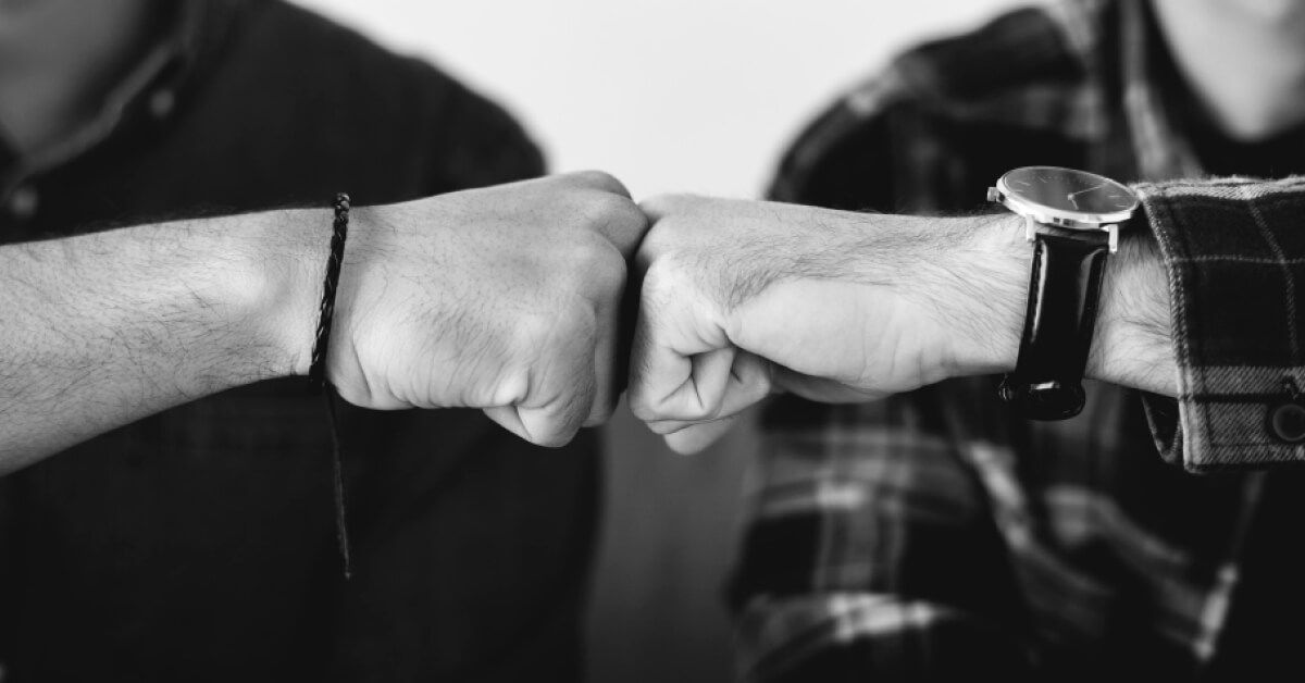 Two men fist bumping