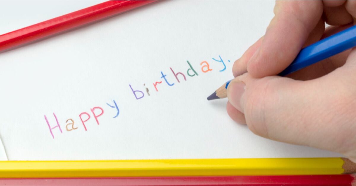 A kid writing happy birthday