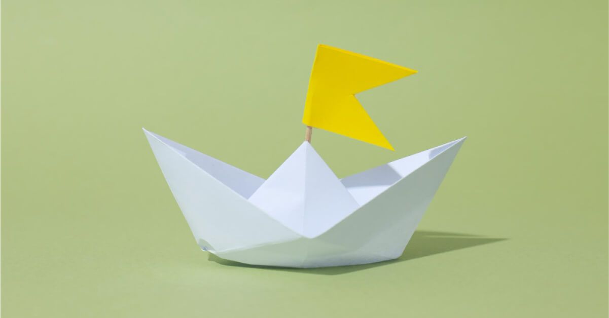 Paper boat with a yellow flag