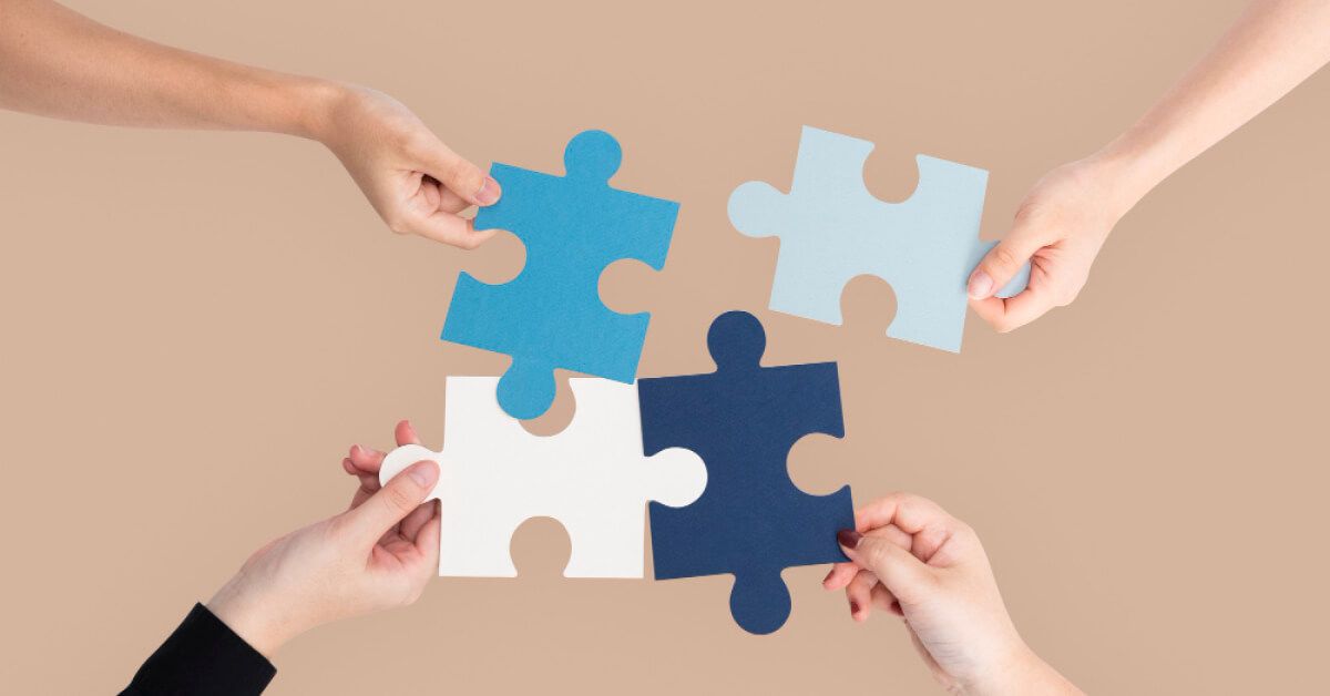 Four people holding pieces of puzzles