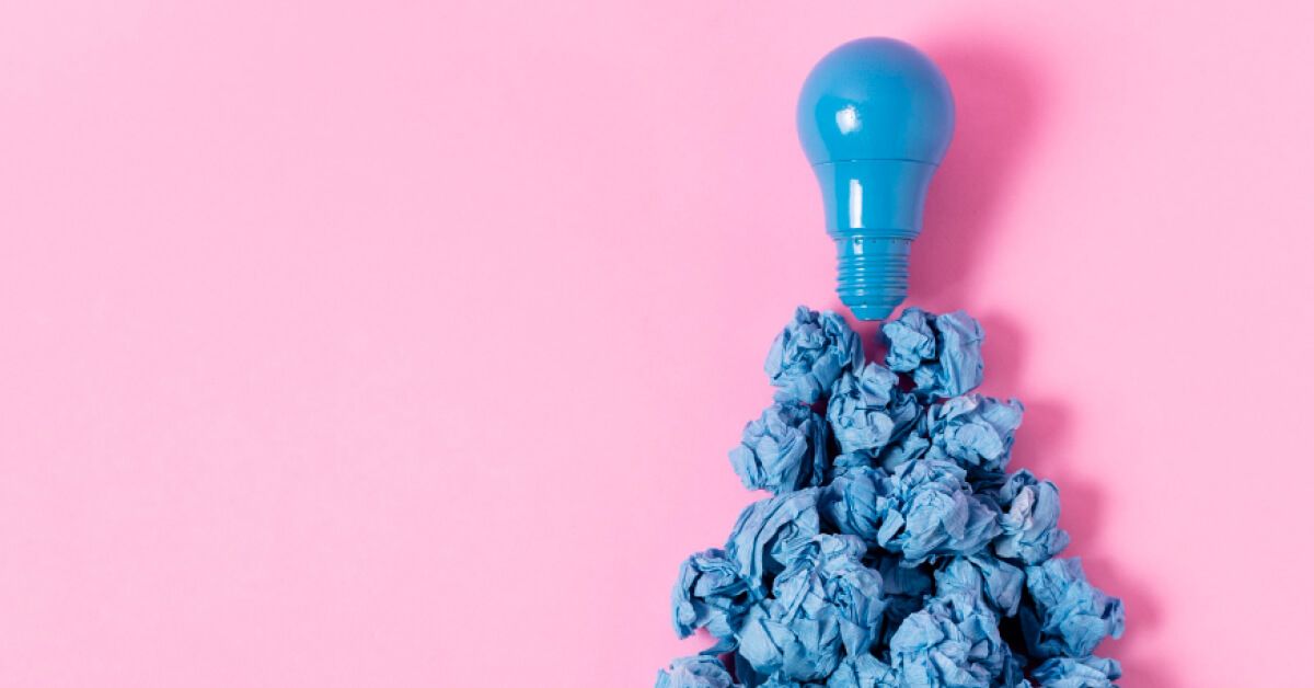 A light bulb on top of blue crushes papers