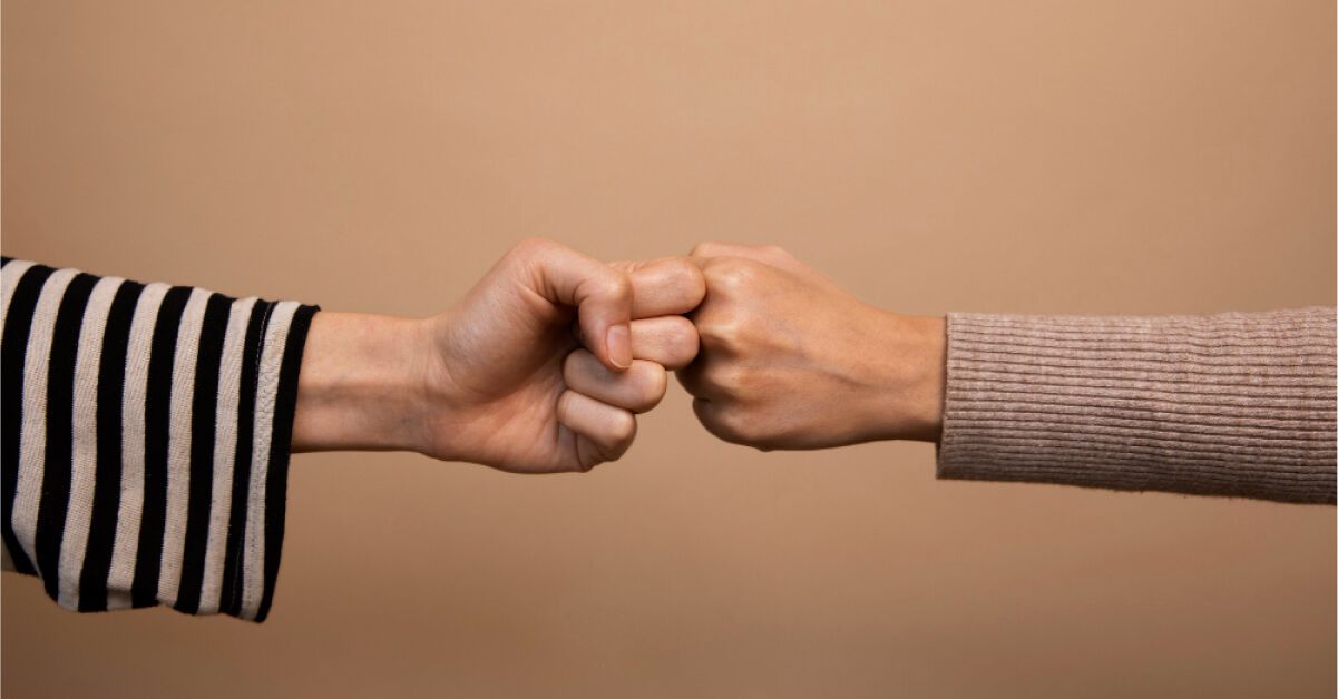 Two people fist bumping