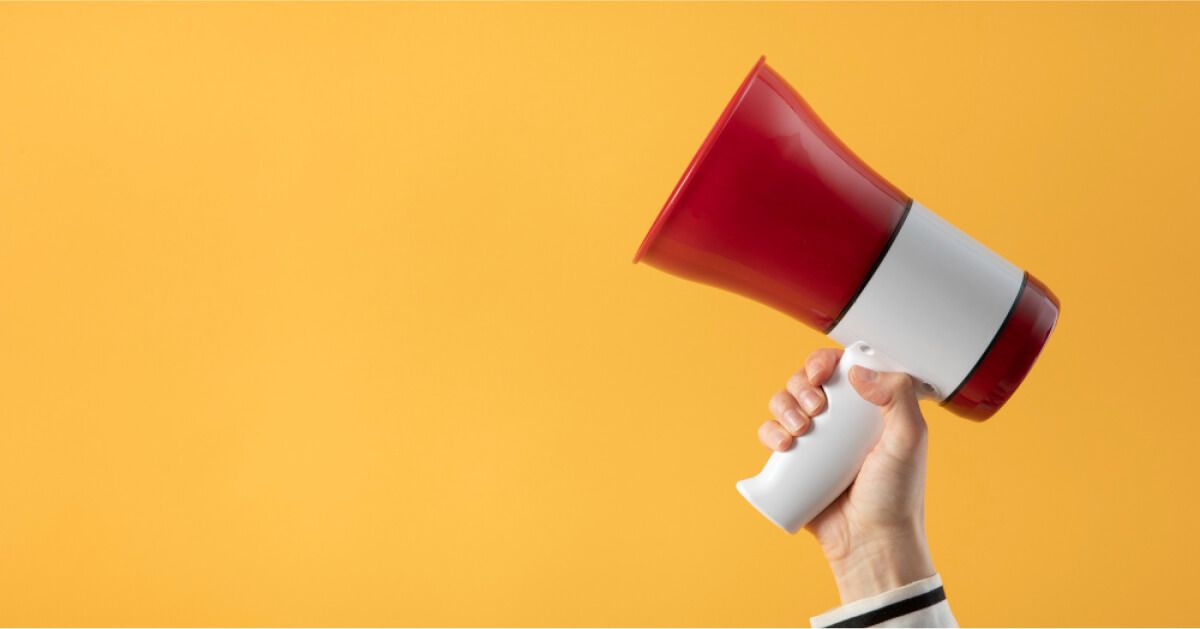 Holding loudspeaker in a yellow background