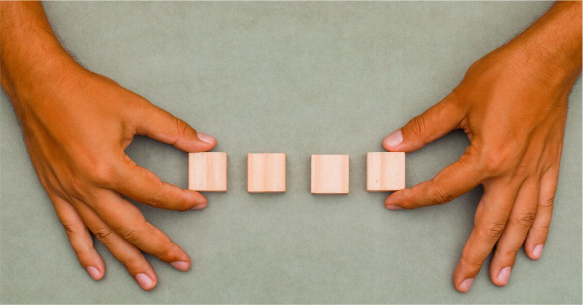 A man holding four wooden blocks