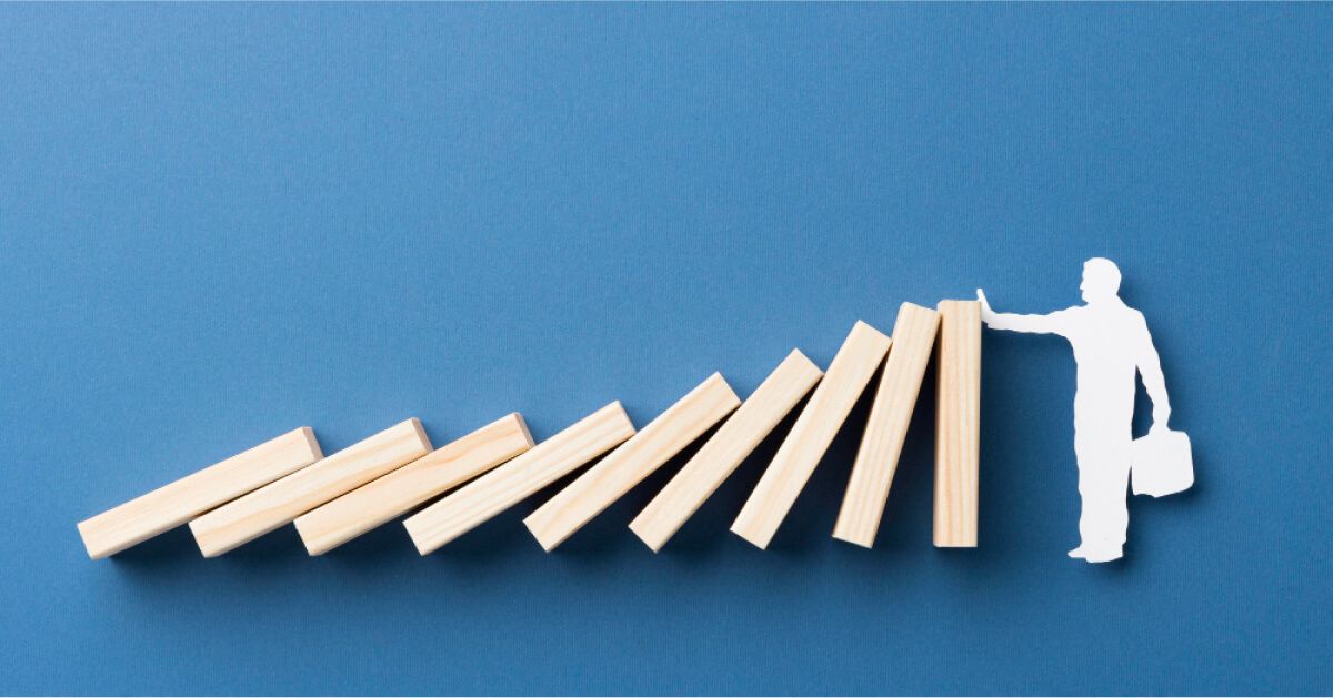 A man stopping jenga from falling