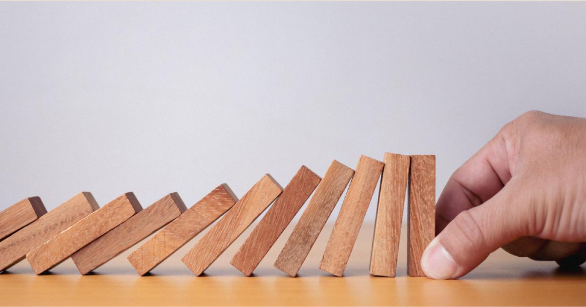 Employee stoping the domino from falling