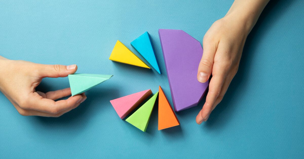 Person arranging color differentiated sections of a physical pie graph