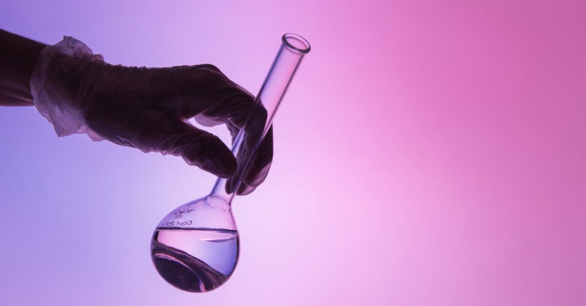 A person holding a science lab beaker 