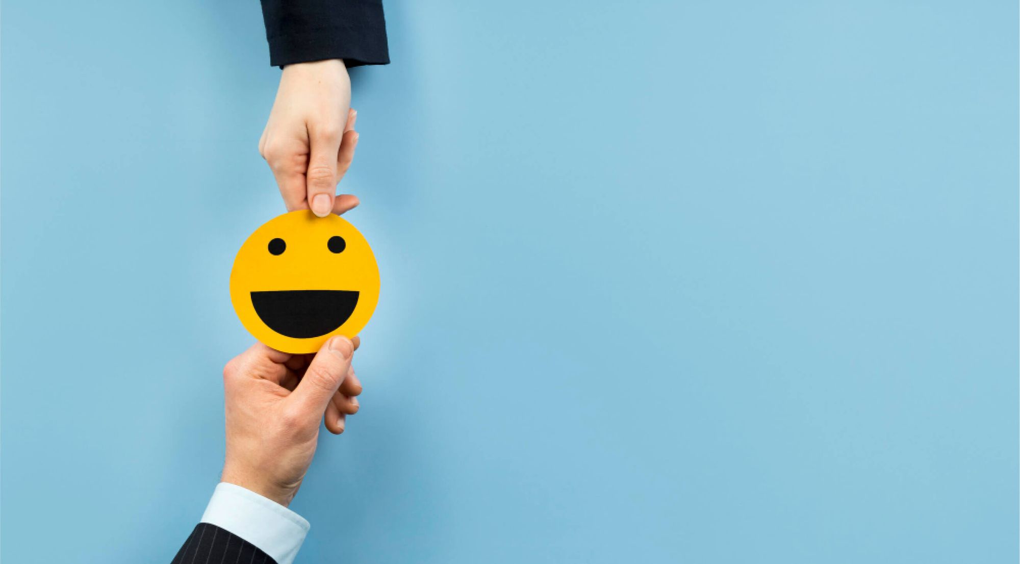 Employee handing a smiley emoji card to employer 