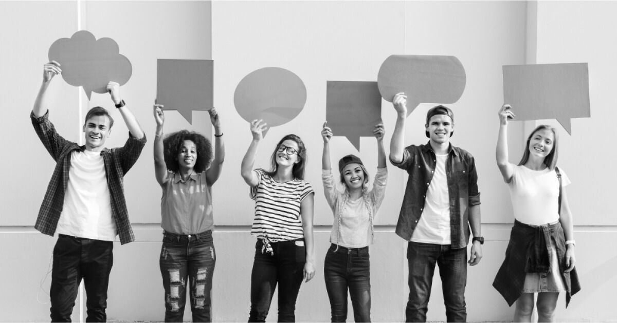 Employees are holding word cloud shaped cardboards 