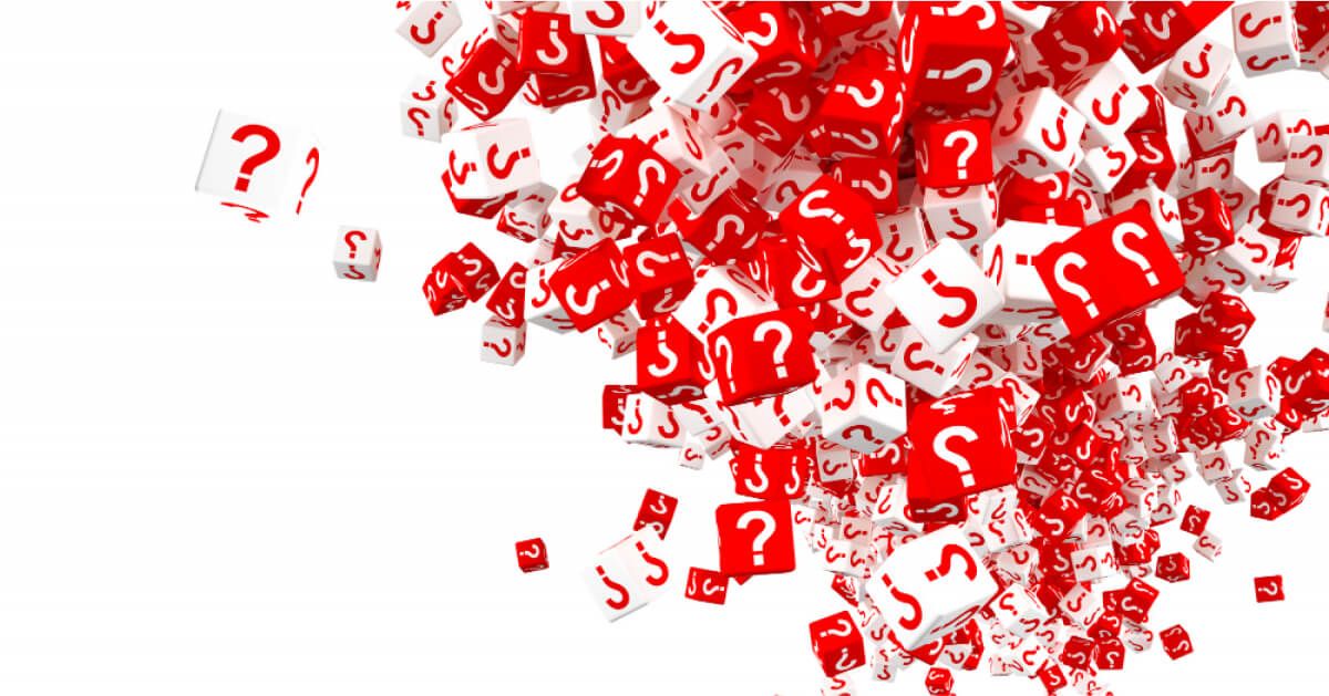 Red and white cubes with question marks on their surfaces spread over a white backdrop