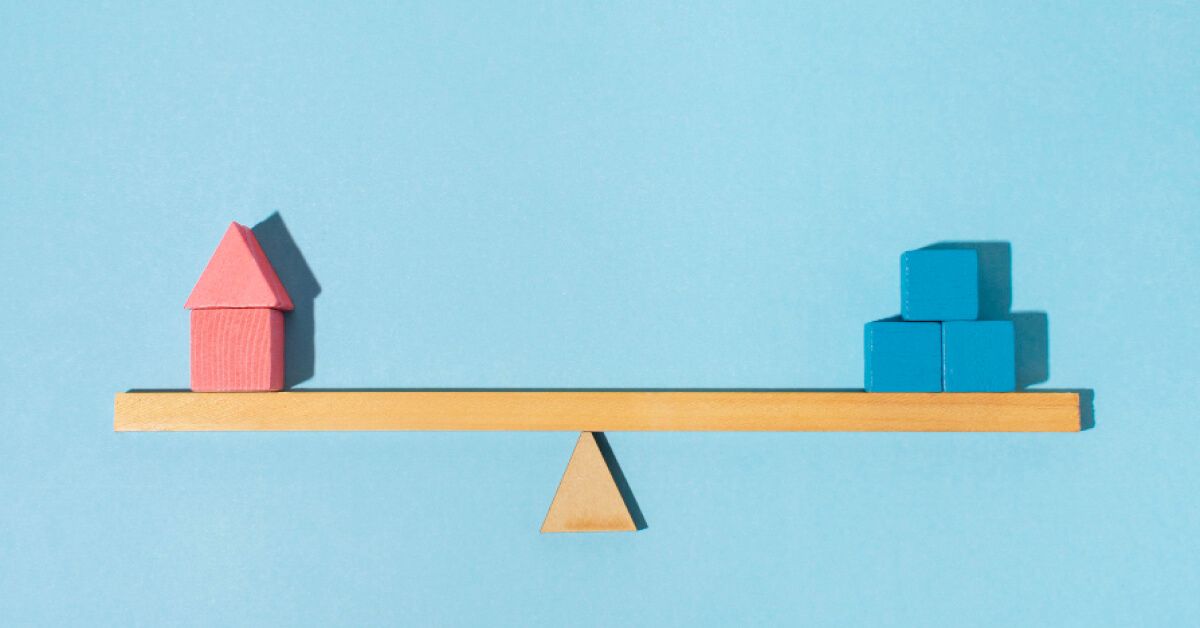 Pink and blue blocks perfectly balanced on a wooden balancing scale