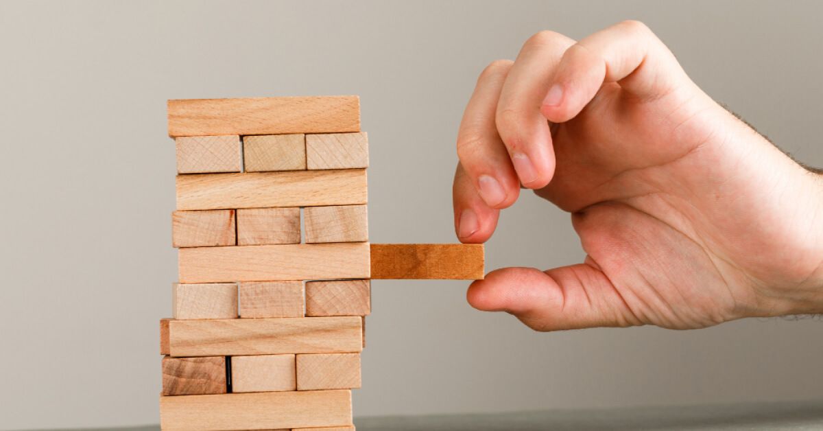 A hand taking jenga game piece 