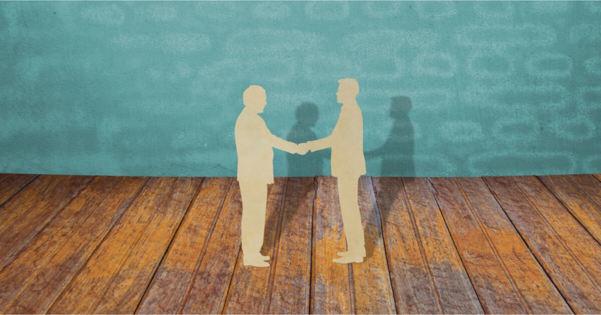 Paper cutout of two people shaking hands