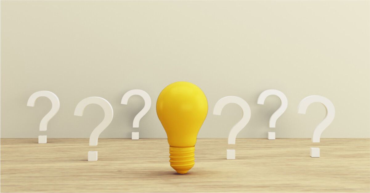 An yellow lightbulb surrounded by lots of question marks