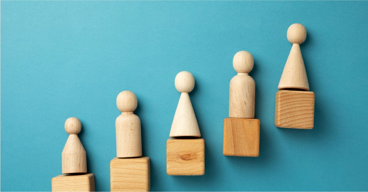 Different pawns placed on wooden blocks that are arranged in a stepped manner