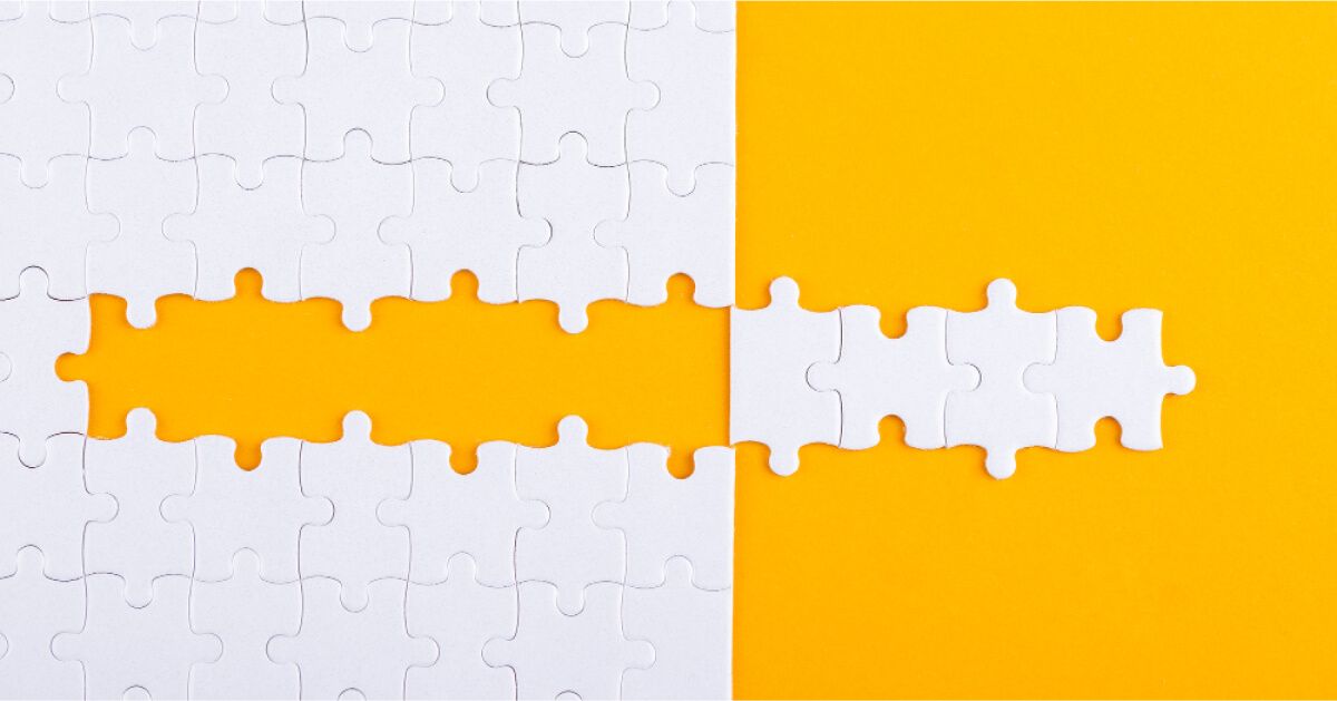 White puzzle pieces laid against a yellow backdrop