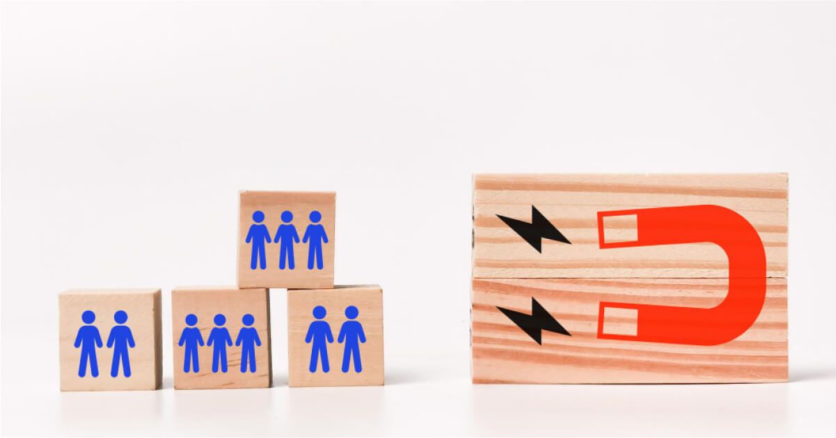 Wooden blocks with blue human figures stacked beside a red magnet illustration.