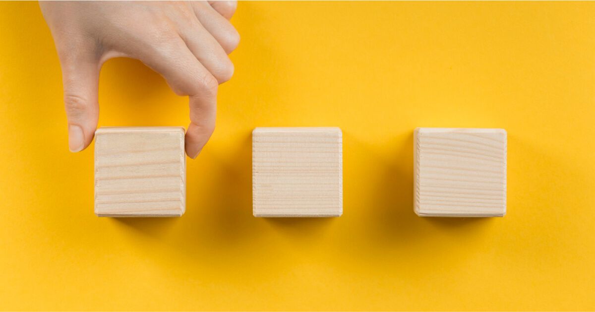 A man placing three wooden blocks