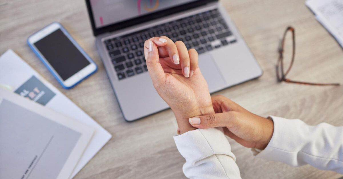 Person checking their pulse rate by holding their wrist