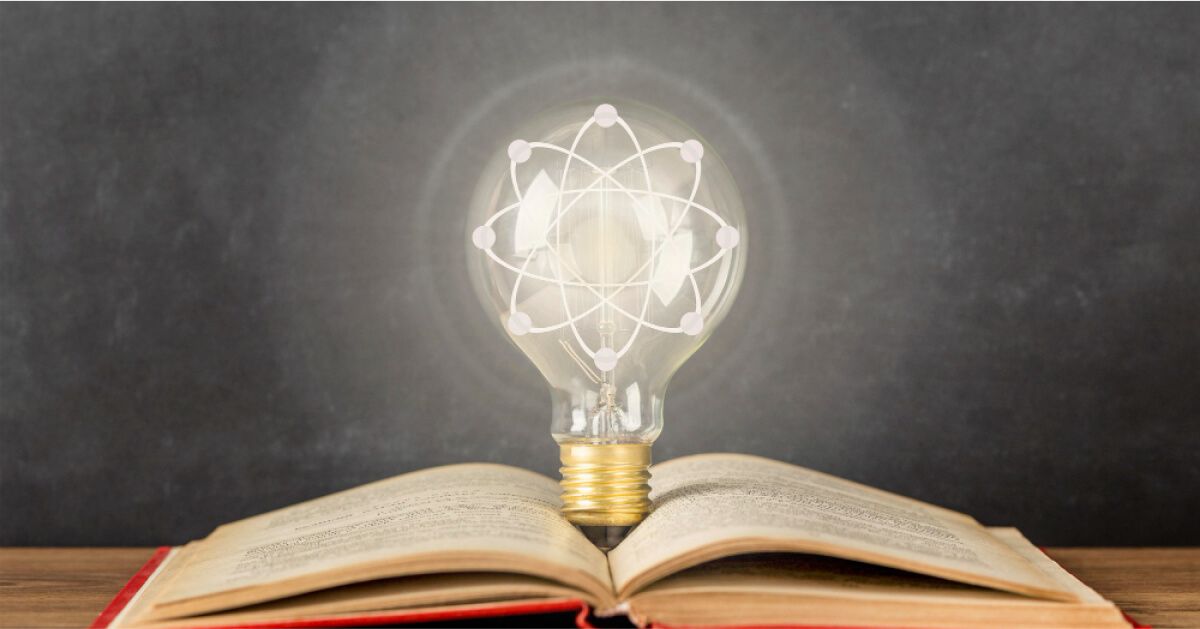 Light bulb with the science logo, illuminated over an open book