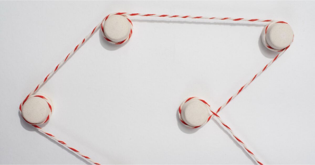 White circular pins connected by red and white striped string.