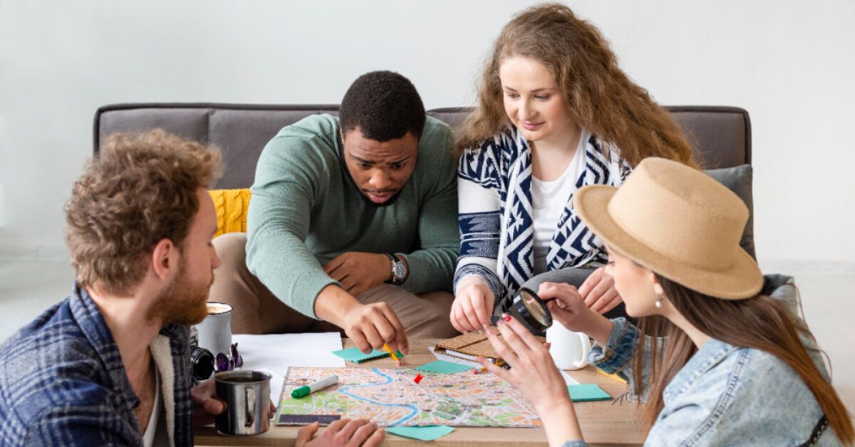 Group of people sitting around a table, playing a board game