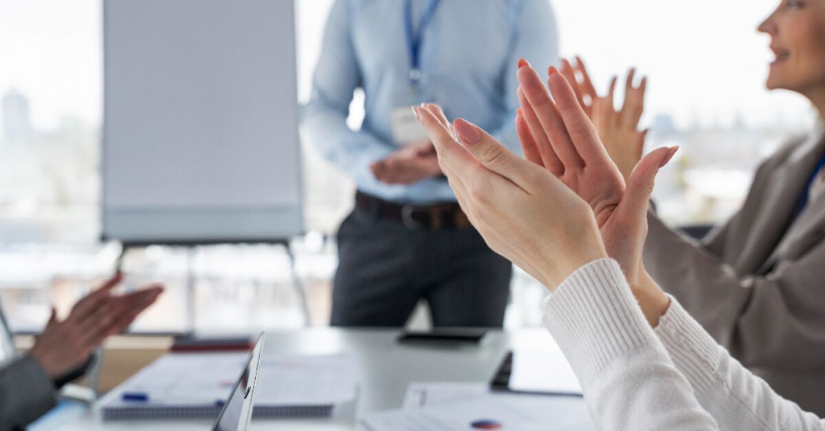 Group of people applauding in a meeting