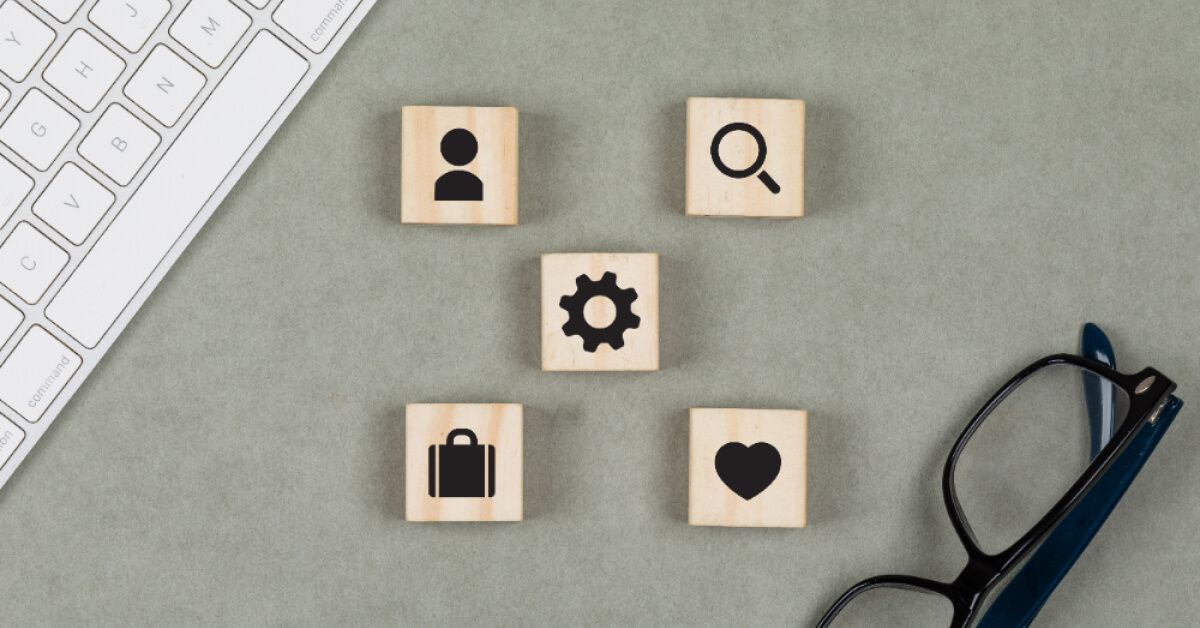 Wooden square blocks with a keyboard and specs nearby 