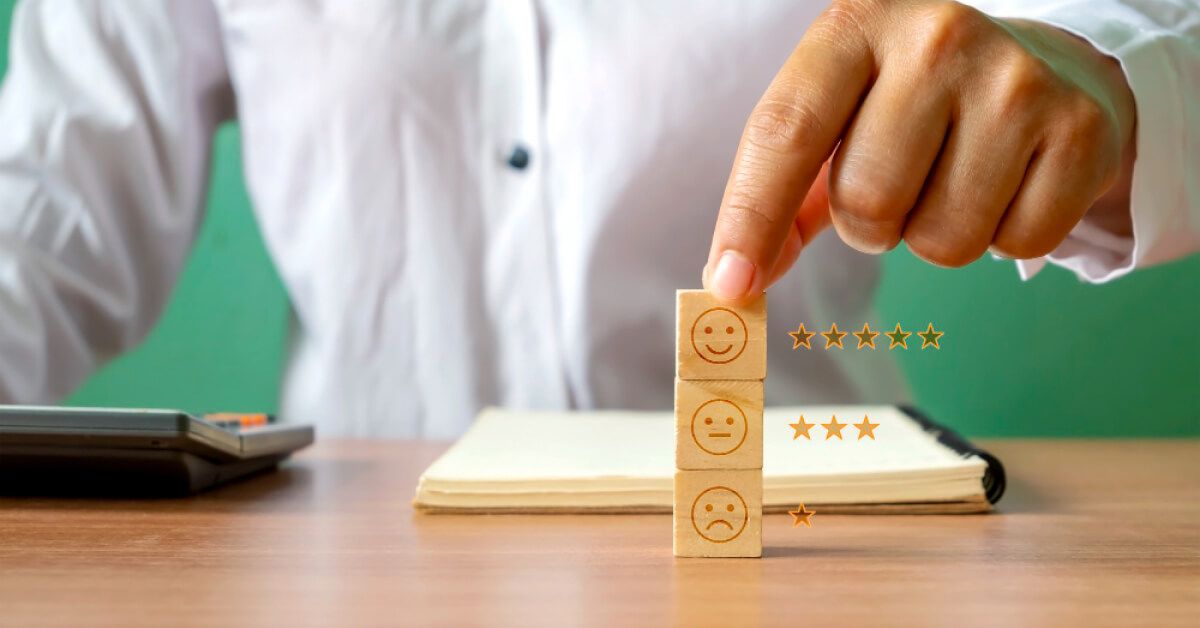 Person holding a stack of wooden chips with different emoji reactions