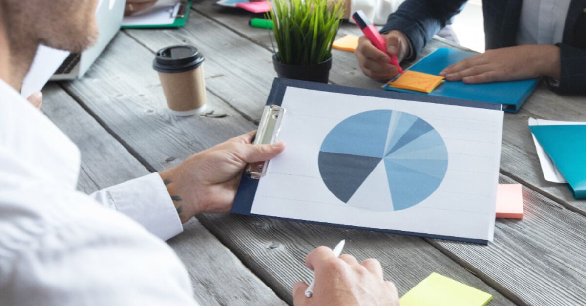 People working at a table with documents and statistics