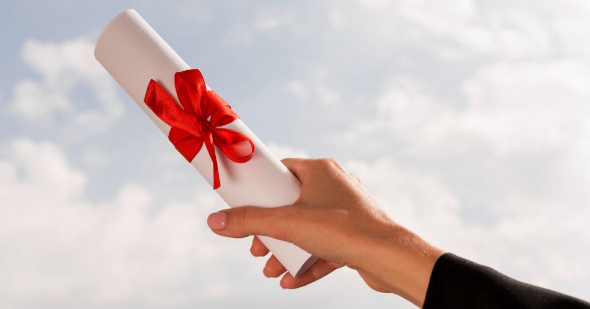 Someone holding a roll of paper with a red ribbon around it