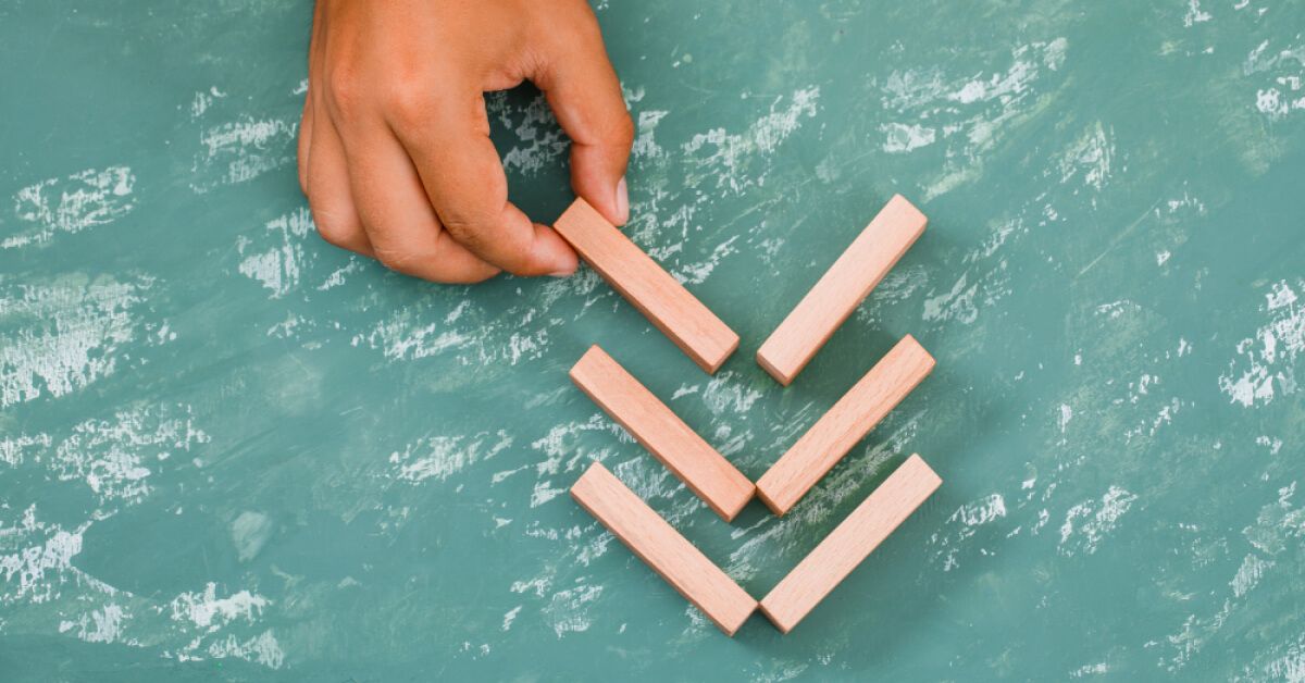 A person arranging blocks in a pattern 