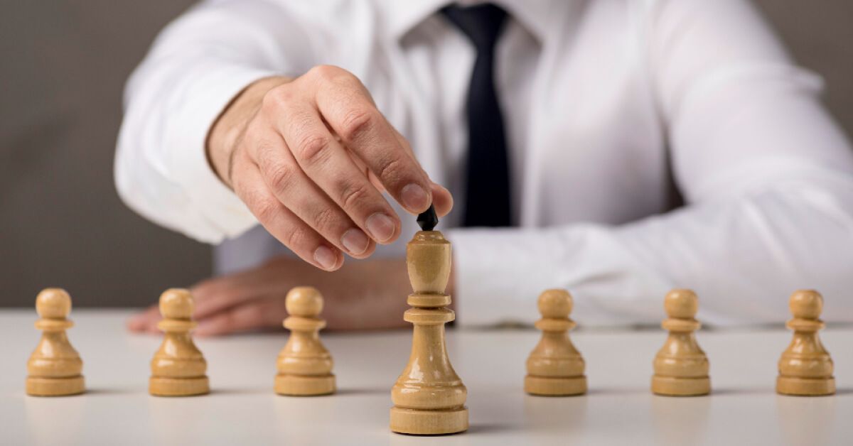 Business person moving a chess piece