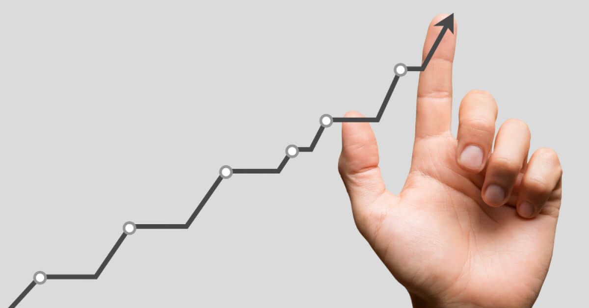 Person moving finger along an upward moving line graph