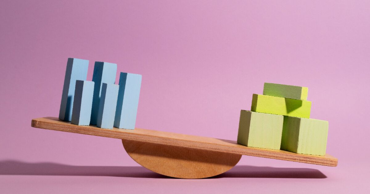 Two sets of colored blocks on a wooden balancing scale