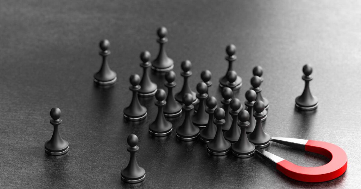 Horseshoe magnet attracting black chess pawns towards it