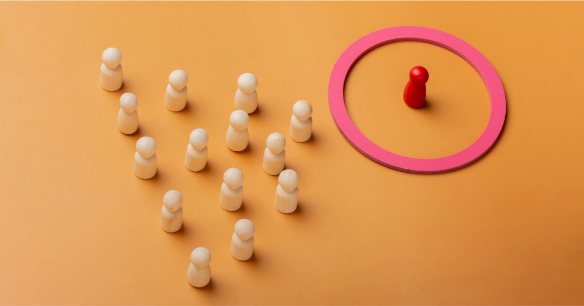 A red pawn inside a circular ring while a group of plain wooden pawns are outside it