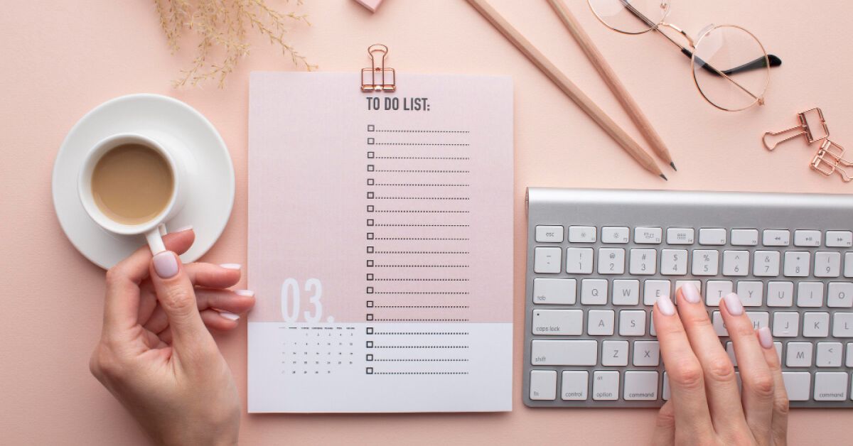 Employee working on a to-do list along side with a coffee